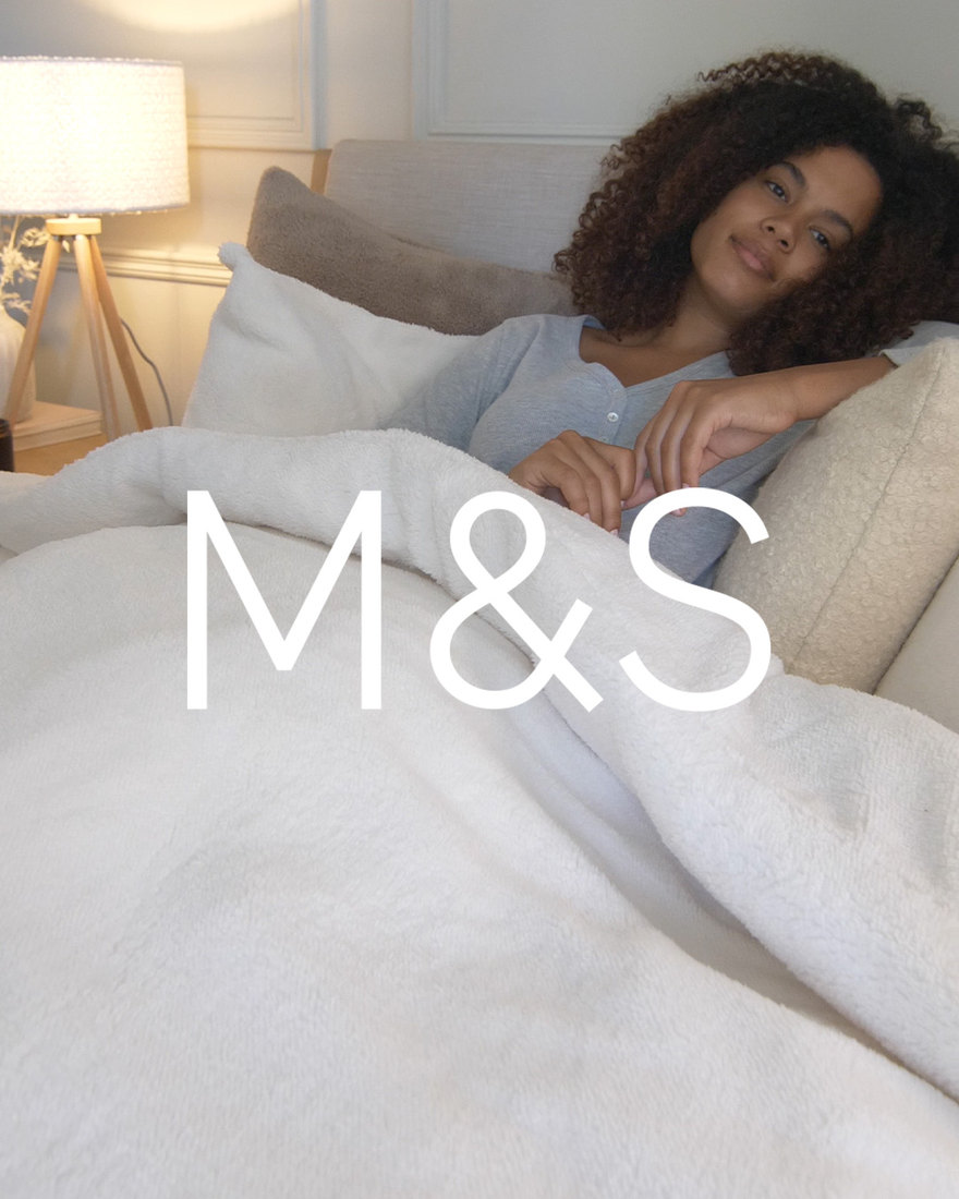 M&S bedding campaign — model wrapped in a fleece throw.